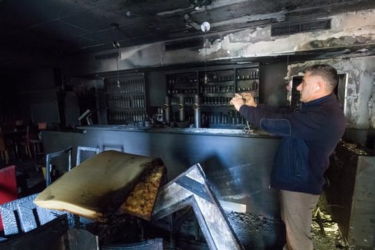 Ali Tulasoglu fotografiert die verkohlten Räume seines türkischen Restaurants in Chemnitz.