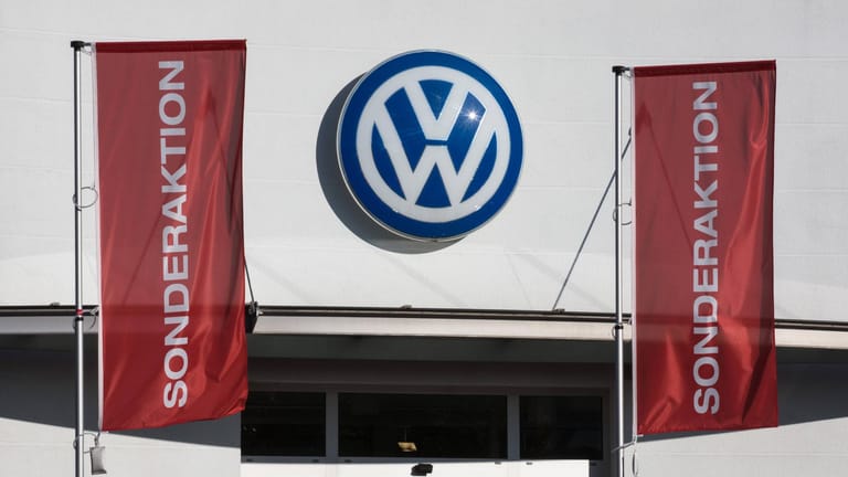 Fahnen mit der Aufschrift Sonderaktion hängen an einem Volkswagen-Autohaus vor einer Fassade mit VW-Emblem