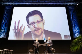 Whistleblower Edward Snowden spricht zu Studenten der Wirtschafts-Uni MCI in Innsbruck. Im Vordergrund Snowden-Anwalt Robert Tibbo (links) und Andreas Altmann (Rektor MCI).