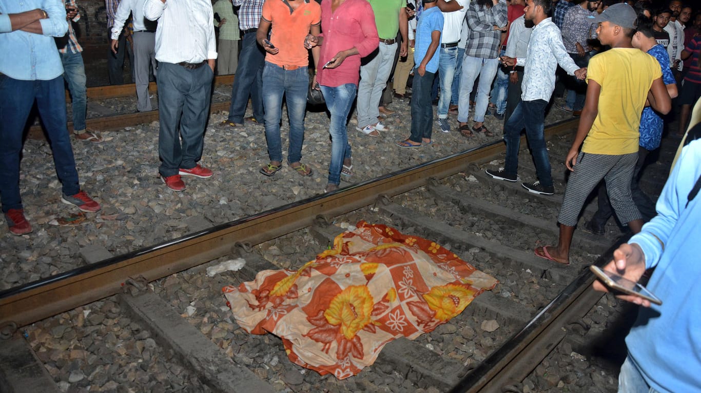 Die Unglücksstelle in Indien: Ein, mit einem Tuch abgedeckter, Körper liegt auf den Bahnschienen.