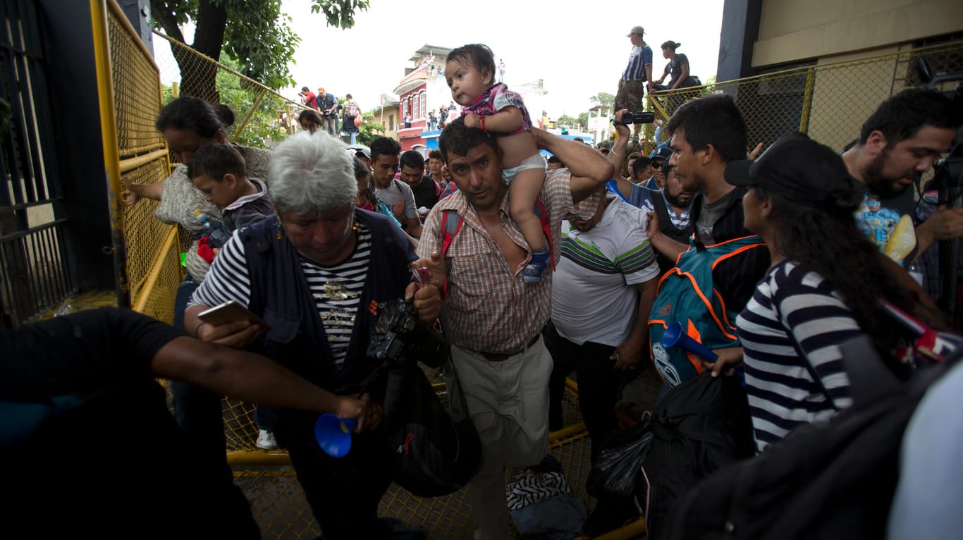 Durchbruch am Grenzzaun: Flüchtlinge aus Honduras drängen ein Tor auf, um nach Mexiko zu gelangen.