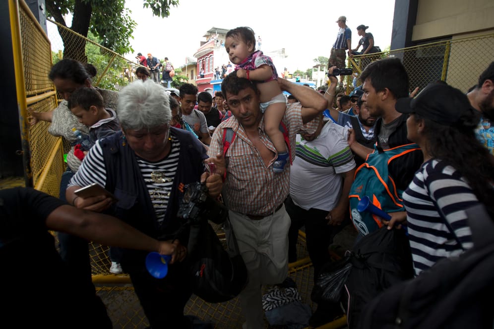 Durchbruch am Grenzzaun: Flüchtlinge aus Honduras drängen ein Tor auf, um nach Mexiko zu gelangen.