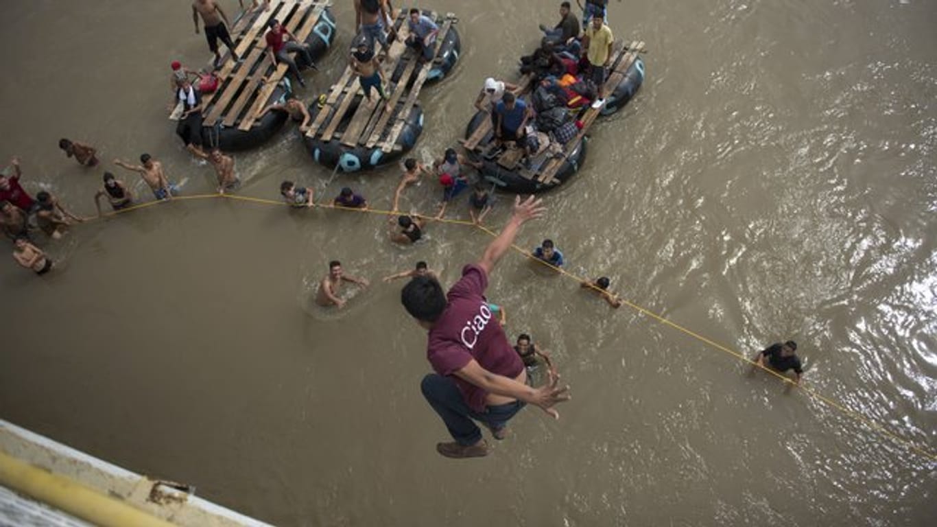 Ein honduranischer Migrant springt von einer Brücke in den Grenzfluss Suchiate.