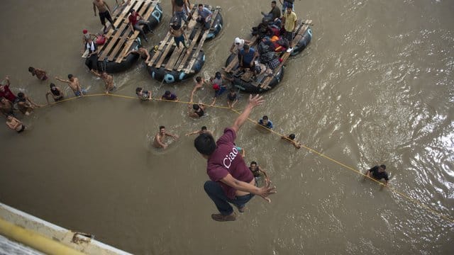 Ein honduranischer Migrant springt von einer Brücke in den Grenzfluss Suchiate. Ein honduranischer Migrant springt von einer Brücke in den Grenzfluss Suchiate.