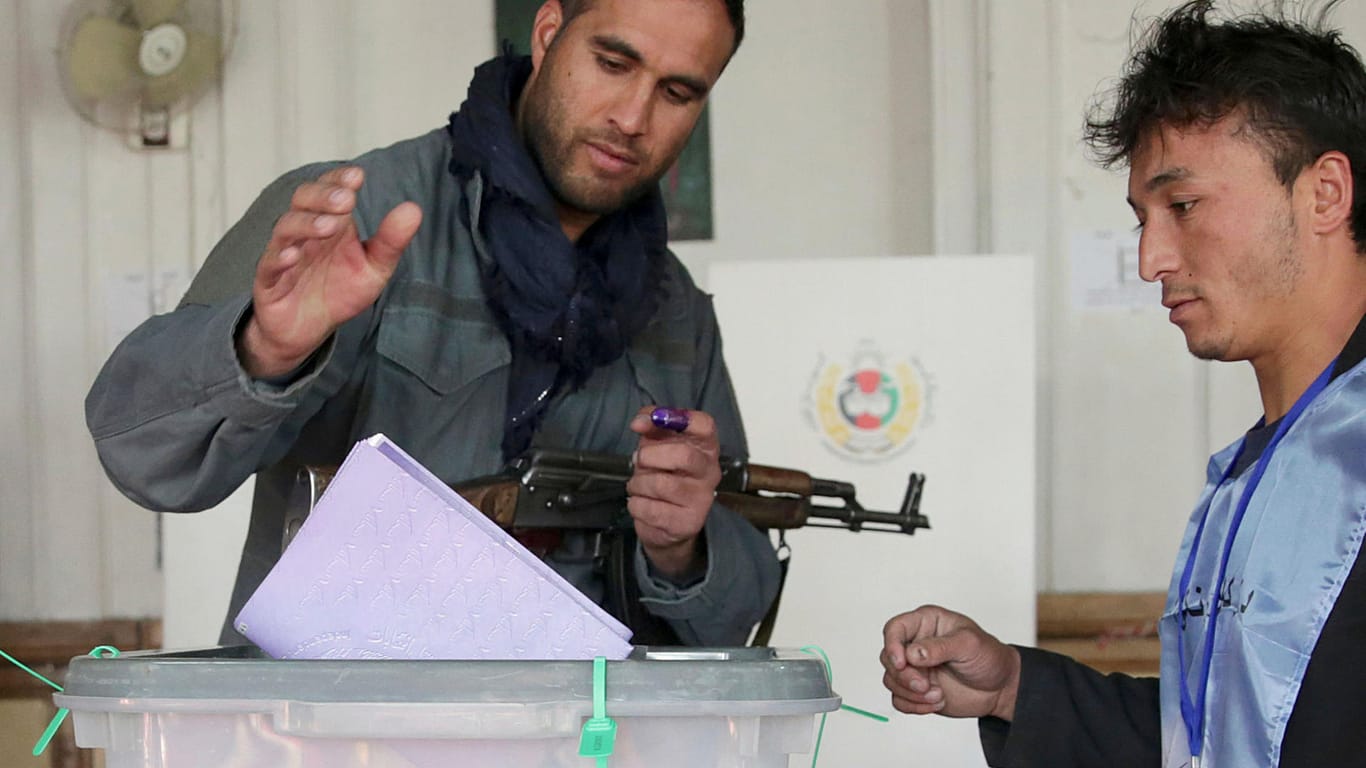 Ein Polizist gibt seine Stimme bei den Parlamentswahlen in einem Wahllokal in der Altstadt von Kabul ab: Der Urnengang in Afghanistan läuft vielerorts nicht reibungslos ab.