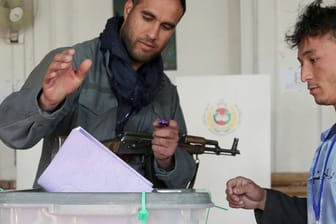 Ein Polizist gibt seine Stimme bei den Parlamentswahlen in einem Wahllokal in der Altstadt von Kabul ab: Der Urnengang in Afghanistan läuft vielerorts nicht reibungslos ab.