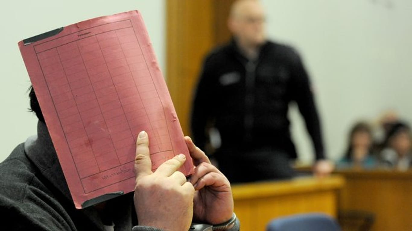 Der ehemalige Krankenpfleger Niels Högel versteckt während eines früheren Prozesses am Landgericht Oldenburg sein Gesicht hinter einem Aktendeckel.