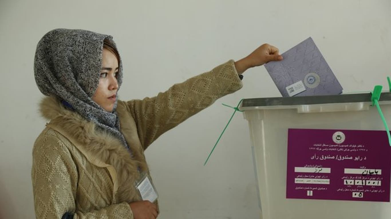 Eine Frau wirft in Bamyan ihren Stimmzettel für die Parlamentswahlen in eine Wahlurne.