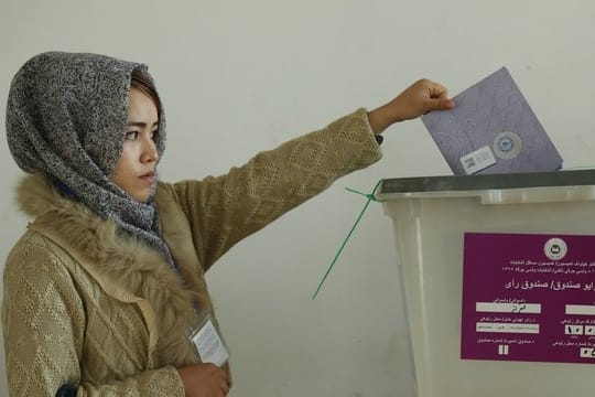 Eine Frau wirft in Bamyan ihren Stimmzettel für die Parlamentswahlen in eine Wahlurne.