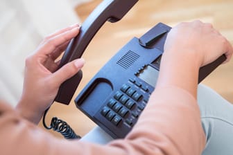 Ein Telefon liegt auf den Knien einer Frau: In Rheinland-Pfalz und Hessen gibt es eine massive Telefonnetz-Störung. (Symbolbild)