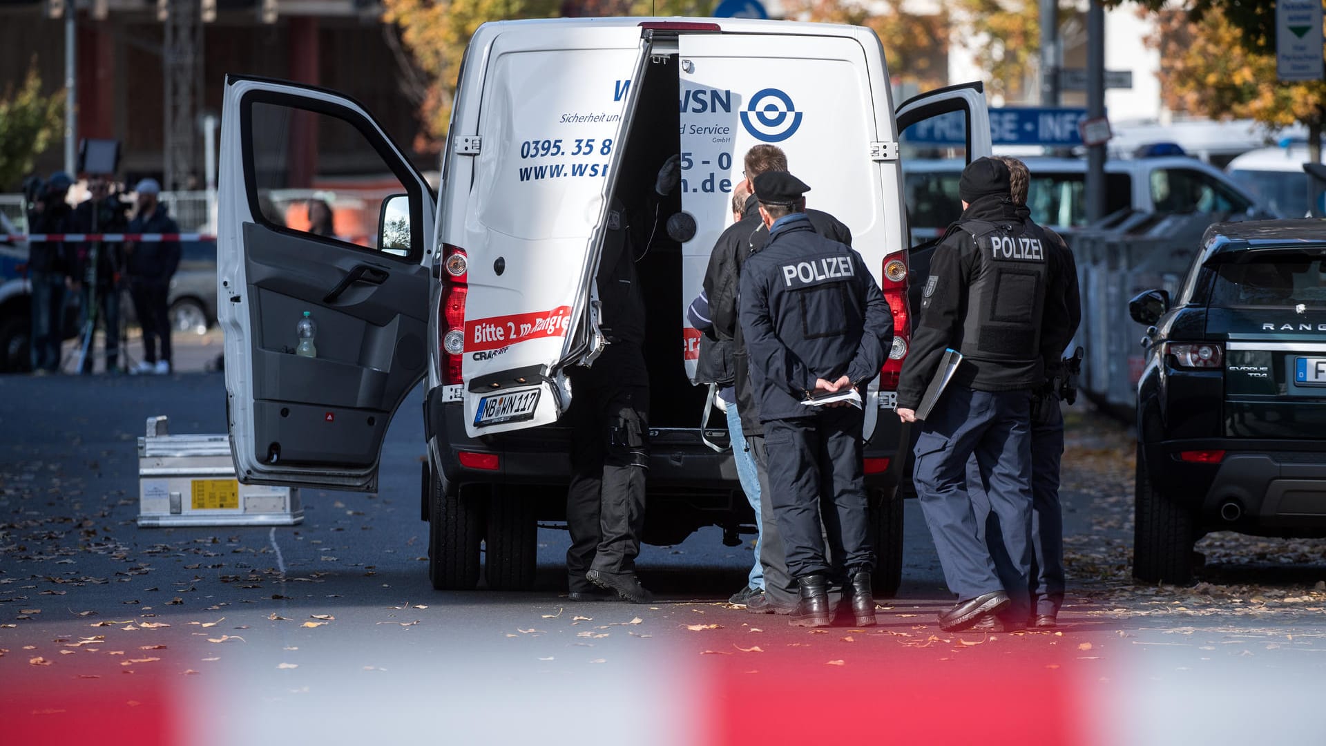 Polizeibeamte stehen an dem aufgebrochenen Geldtransporter in Mitte: Zunächst nahmen die Täter mehrere Geldkisten mit – doch die gingen auf der Flucht verloren. (Archivbild) Polizeibeamte stehen an dem aufgebrochenen Geldtransporter in Mitte: Zunächst nahmen die Täter mehrere Geldkisten mit – doch die gingen auf der Flucht verloren. (Archivbild)