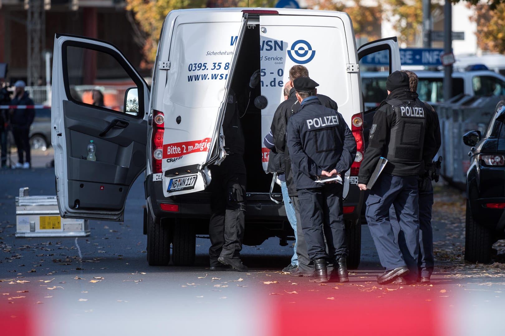 Polizeibeamte stehen an dem aufgebrochenen Geldtransporter in Mitte: Zunächst nahmen die Täter mehrere Geldkisten mit – doch die gingen auf der Flucht verloren. (Archivbild)