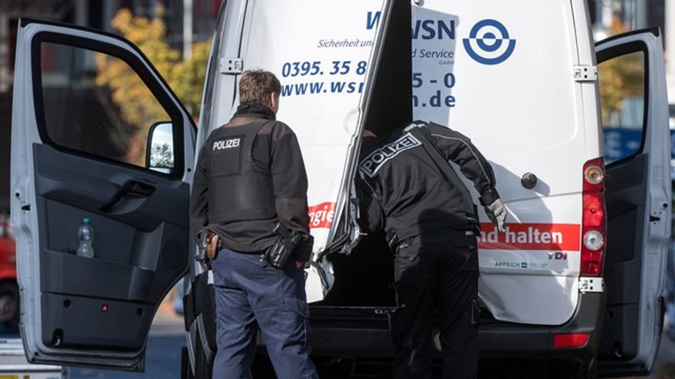 Polizeibeamte stehen an dem aufgebrochenen Geldtransporter in Berlin-Mitte.