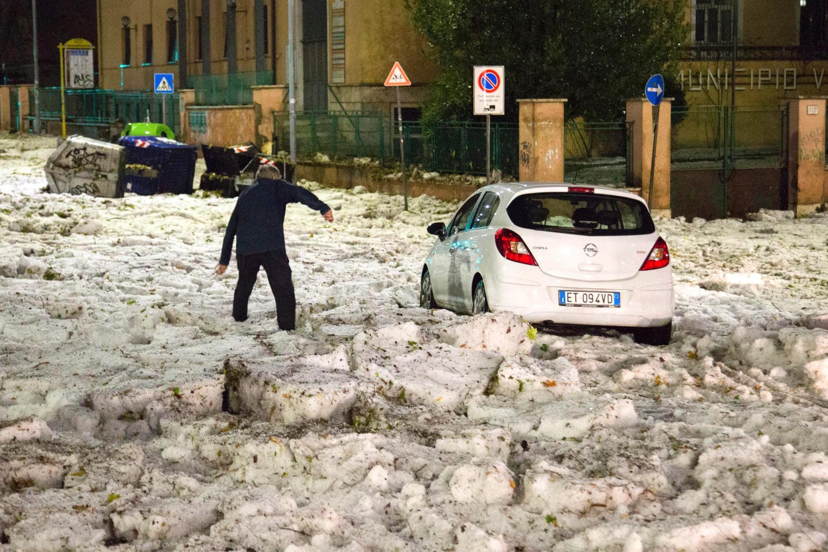Ein Mann versucht, ein durch Hagelmassen blockiertes Auto zu erreichen: Besonders im östlichen Teil von Rom kam viel Hagel herunter.