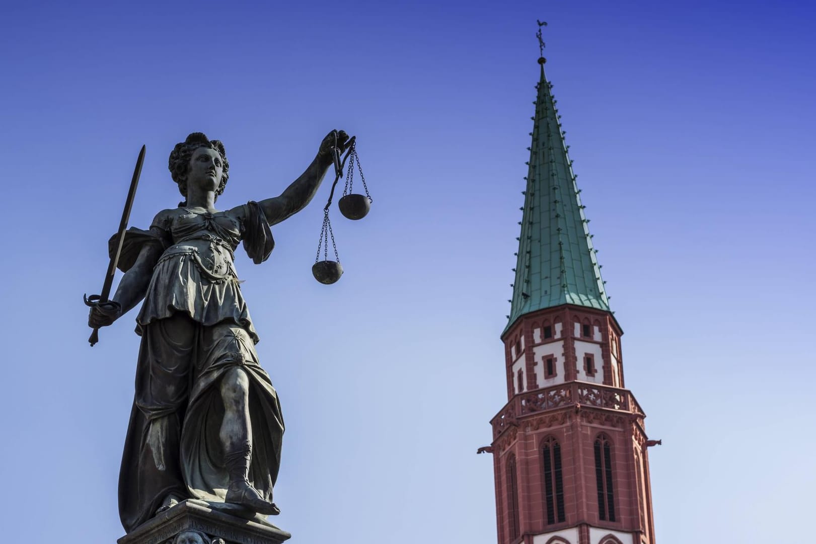 Die Justitita auf dem Gerechtigkeitsbrunnen, dahinter die Nikolaikirche in Frankfurt am Main: Die Hessen stimmen über insgesamt 15 Änderungen ihrer Landesverfassung ab. (Archivbild)