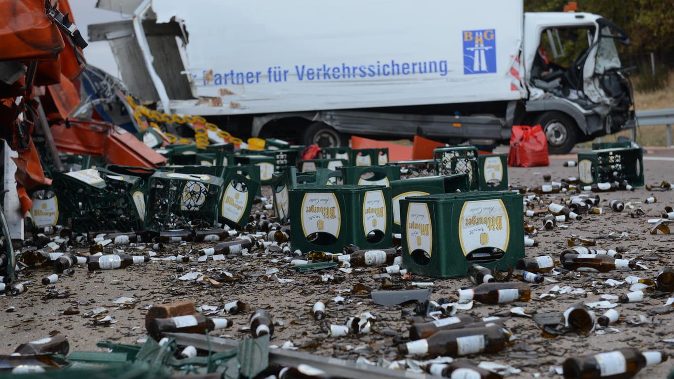 Zerbrochene Bierflaschen und Bierkästen liegen auf der Fahrbahn: Bei dem Unfall wurde ein Mensch wurde schwer und ein weiterer leicht verletzt.