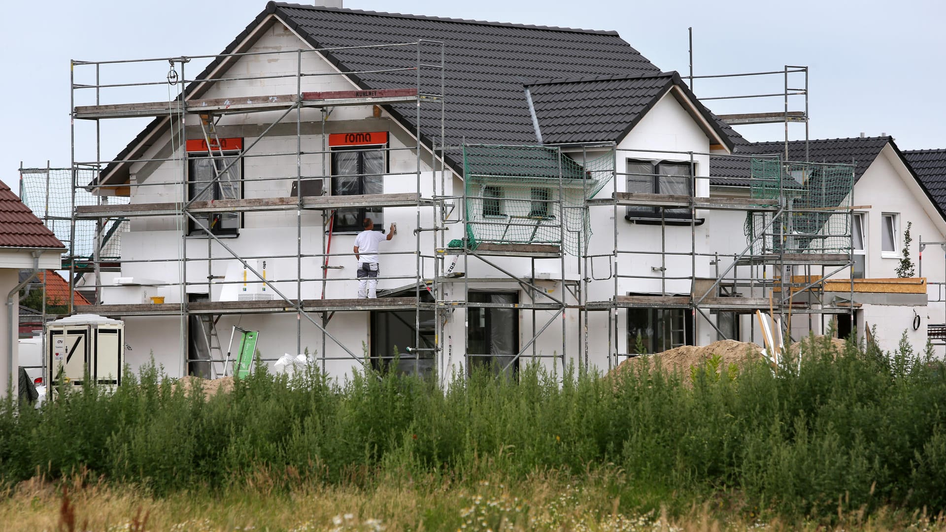 Bauarbeiter arbeiten an der Fertigstellung von Einfamilienhäusern: Mit dem Baukindergeld möchte die Regierung dem Wohnungsmangel entgegenwirken. Bauarbeiter arbeiten an der Fertigstellung von Einfamilienhäusern: Mit dem Baukindergeld möchte die Regierung dem Wohnungsmangel entgegenwirken.