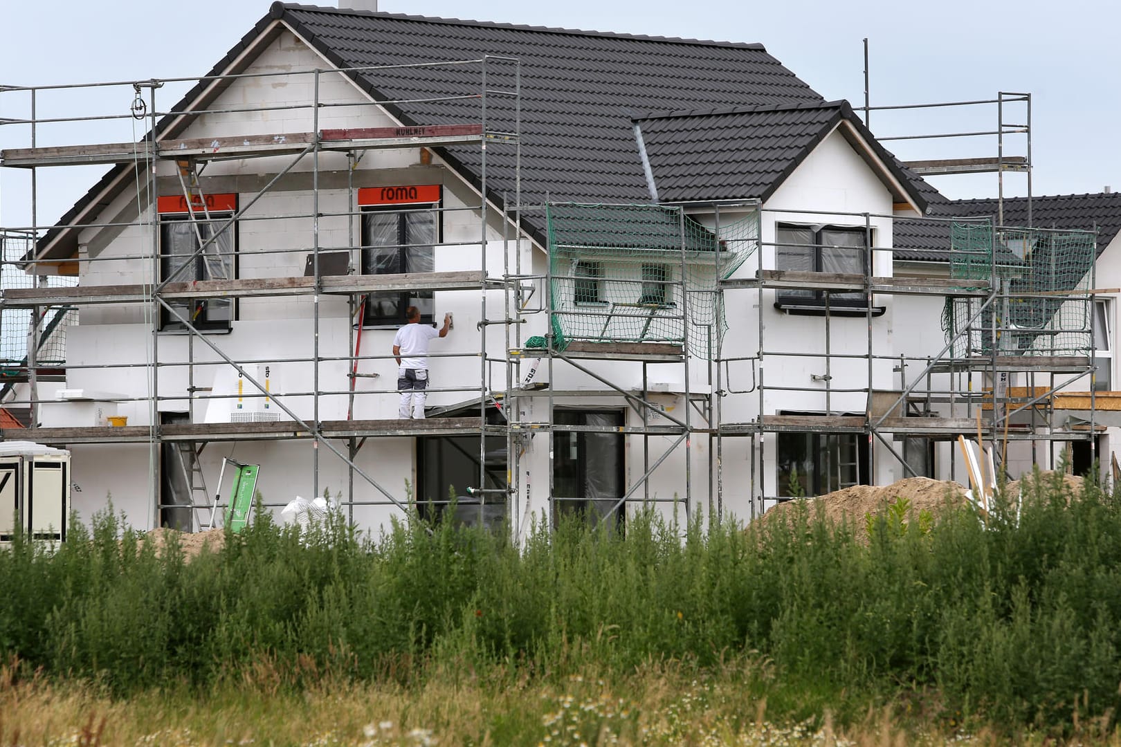 Bauarbeiter arbeiten an der Fertigstellung von Einfamilienhäusern: Mit dem Baukindergeld möchte die Regierung dem Wohnungsmangel entgegenwirken.