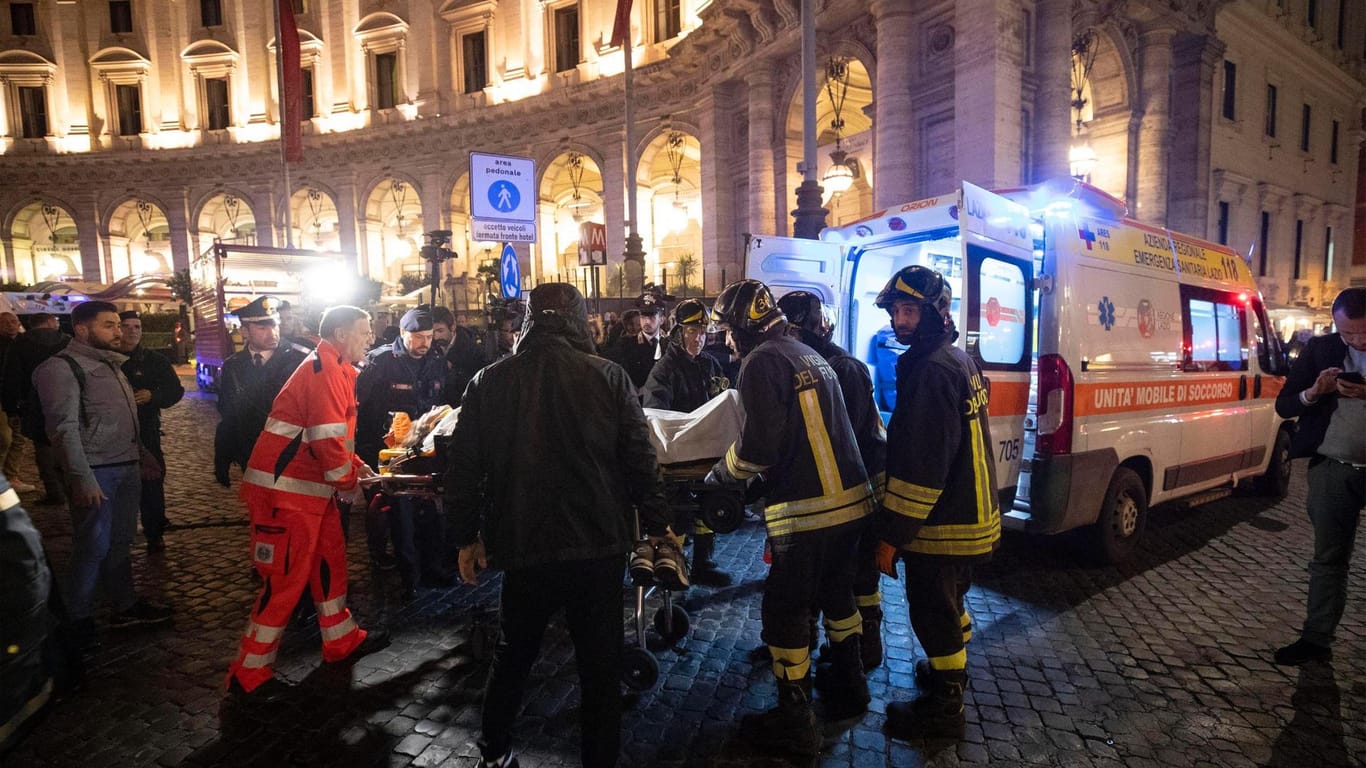 Rettungskräfte tragen eine verletzte Person in einen Krankenwagen: Bei einem folgenschweren Rolltreppen-Unglück in einer römischen U-Bahnstation haben sich 24 Menschen Verletzungen zugezogen.