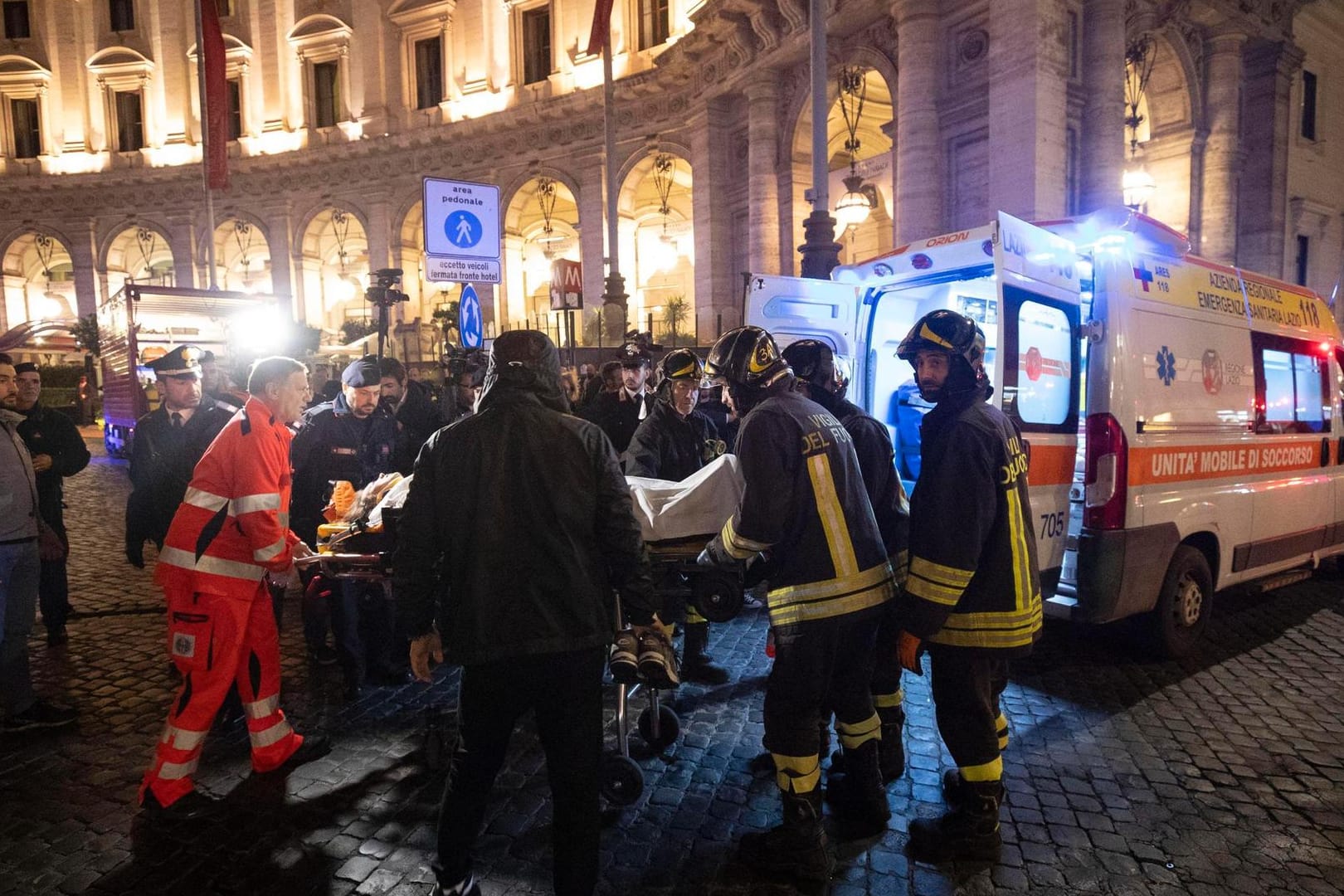 Rettungskräfte tragen eine verletzte Person in einen Krankenwagen: Bei einem folgenschweren Rolltreppen-Unglück in einer römischen U-Bahnstation haben sich 24 Menschen Verletzungen zugezogen.
