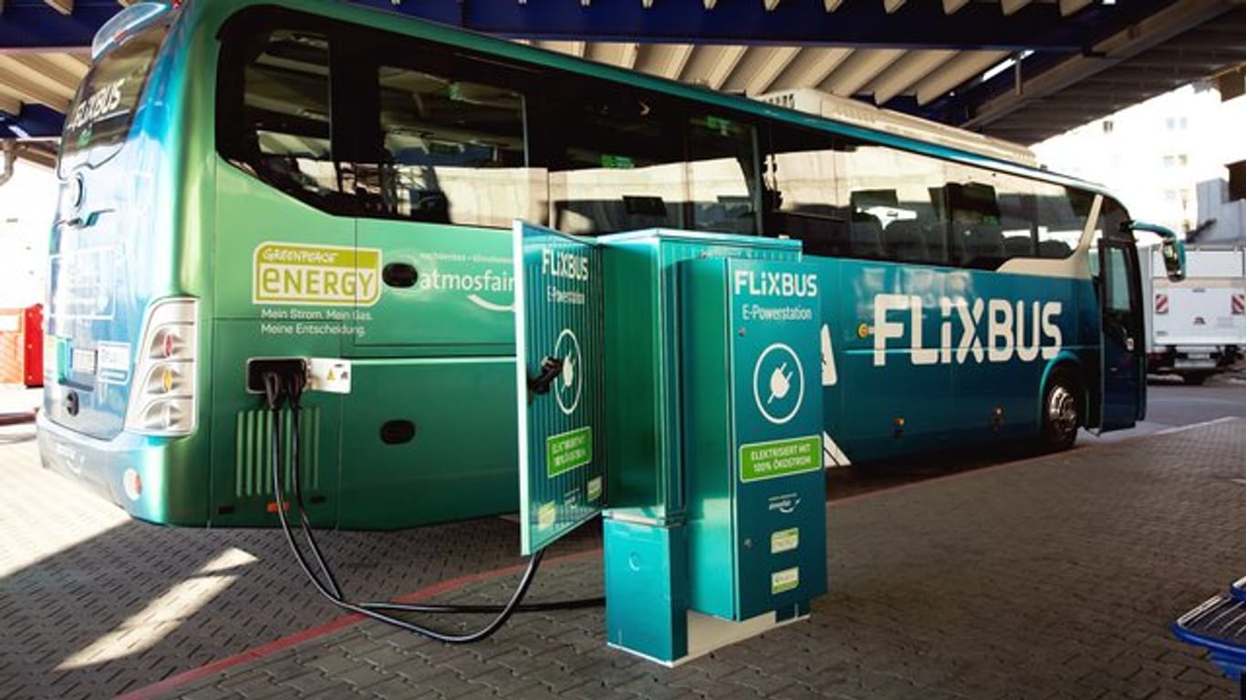 Der erste Elektro-Fernbus des Unternehmens "Flixbus" steht neben einer Strom-Ladestation.