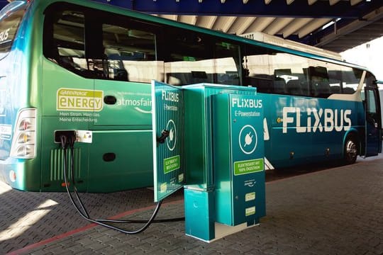 Der erste Elektro-Fernbus des Unternehmens "Flixbus" steht neben einer Strom-Ladestation.