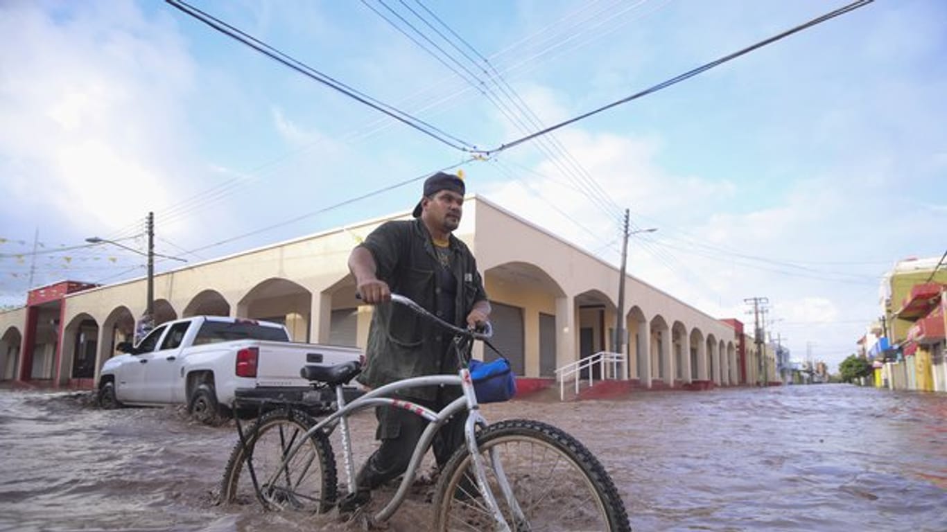 Mit dem Fahrrad auf einer überfluteten Straße in Gemeinde Tecuala in Nayarit.