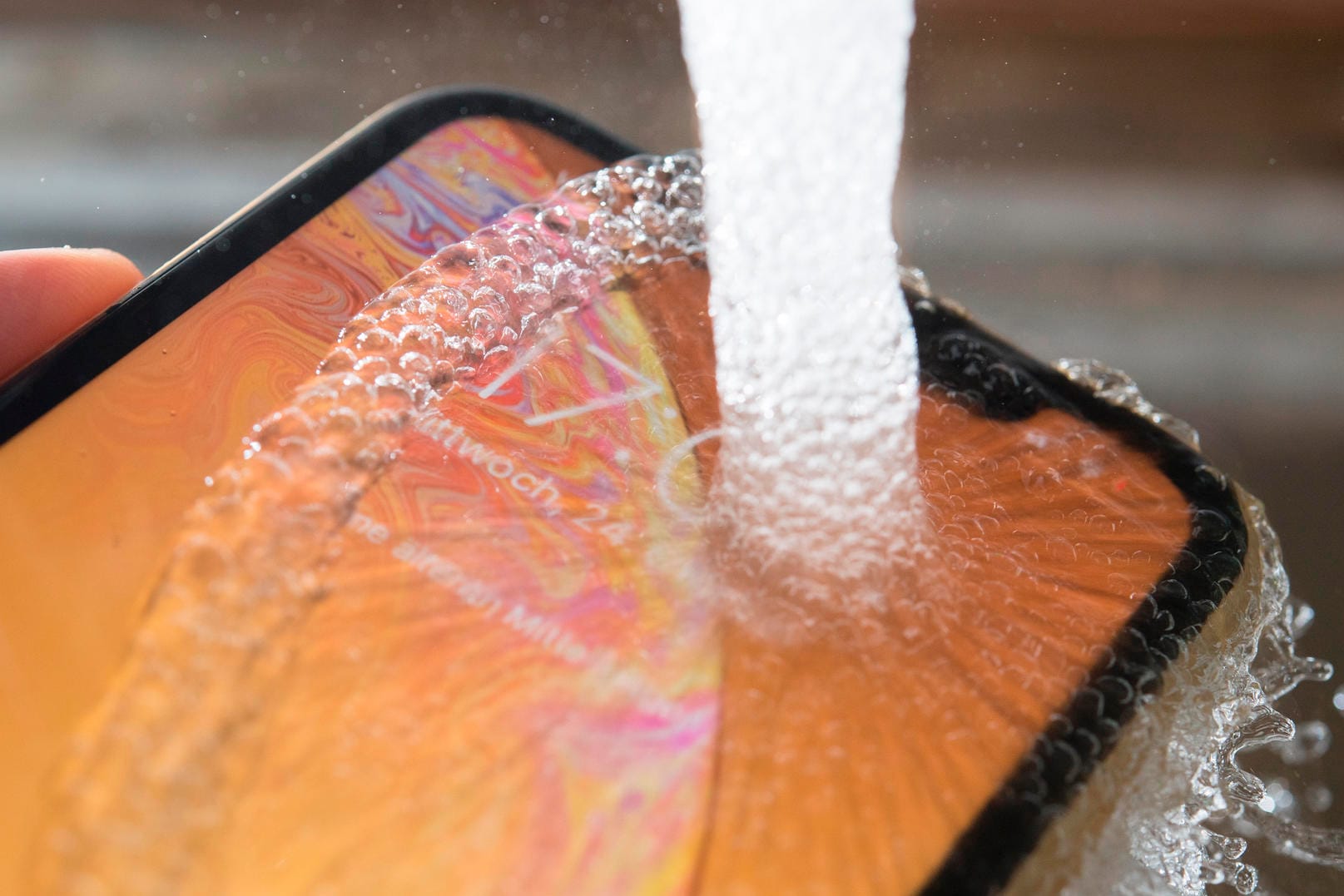 iPhone XR unter laufendem Wasser: Das Gehäuse ist nach der Norm IP67 gegen Staub und Spritzwasser geschützt. Man kann es einfach abspülen.