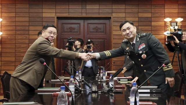 Der südkoreanische General Kim Do-gyun (r) gibt dem nordkoreanischen General An Ik San bei einem Treffen im Grenzdorf Panmunjom die Hand.