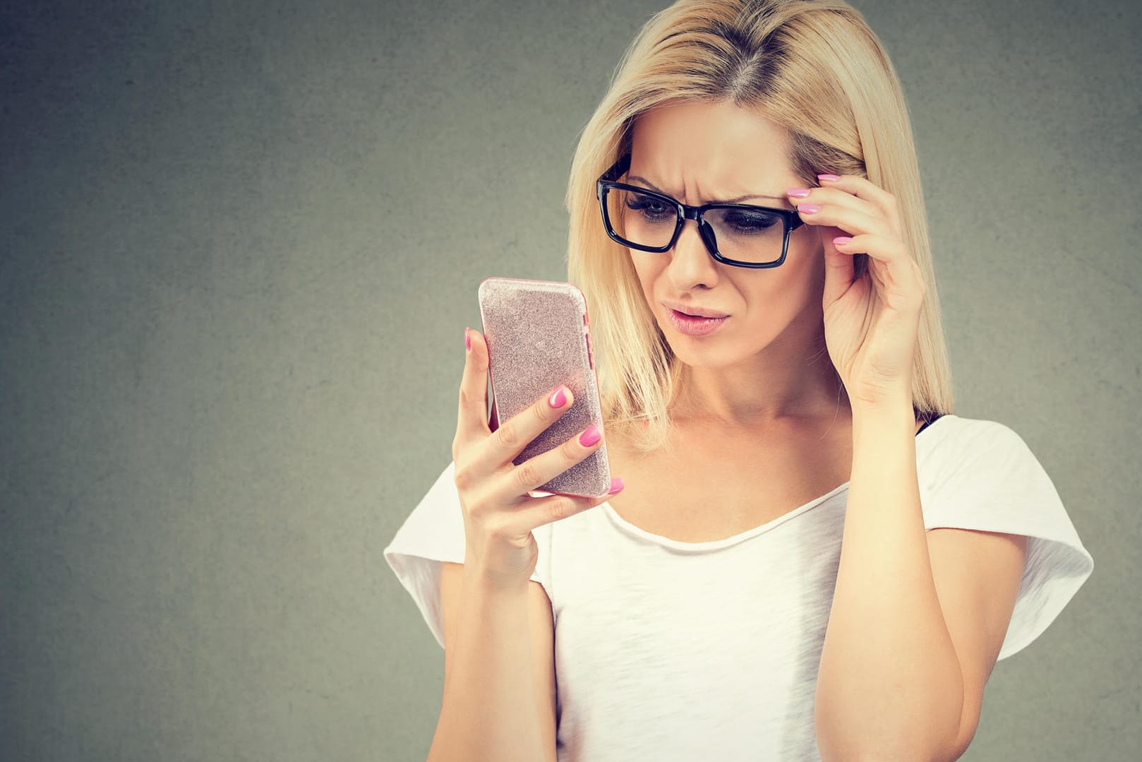 Eine Frau blickt genervt auf ihr Smartphone: Googles "Nearby Notifications" wurde vor allem für Spam-Mitteilungen genutzt.