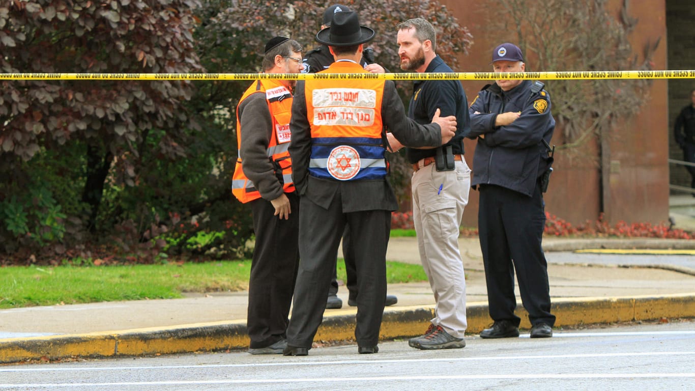 Polizisten und Angehörige einer jüdischen Bestattungsgesellschaft nach dem Anschlag in Pittsburgh: Der mutmaßliche Schütze hatte seine Tat auf Gab.com angekündigt.