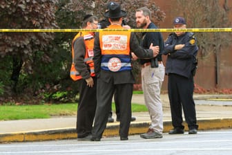 Polizisten und Angehörige einer jüdischen Bestattungsgesellschaft nach dem Anschlag in Pittsburgh: Der mutmaßliche Schütze hatte seine Tat auf Gab.com angekündigt.
