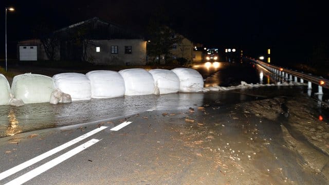 Eingepackte Heuballen und Sandsäcke liegen als Barriere gegen Wasser und Schlamm auf der Brenner-Bundesstraße.