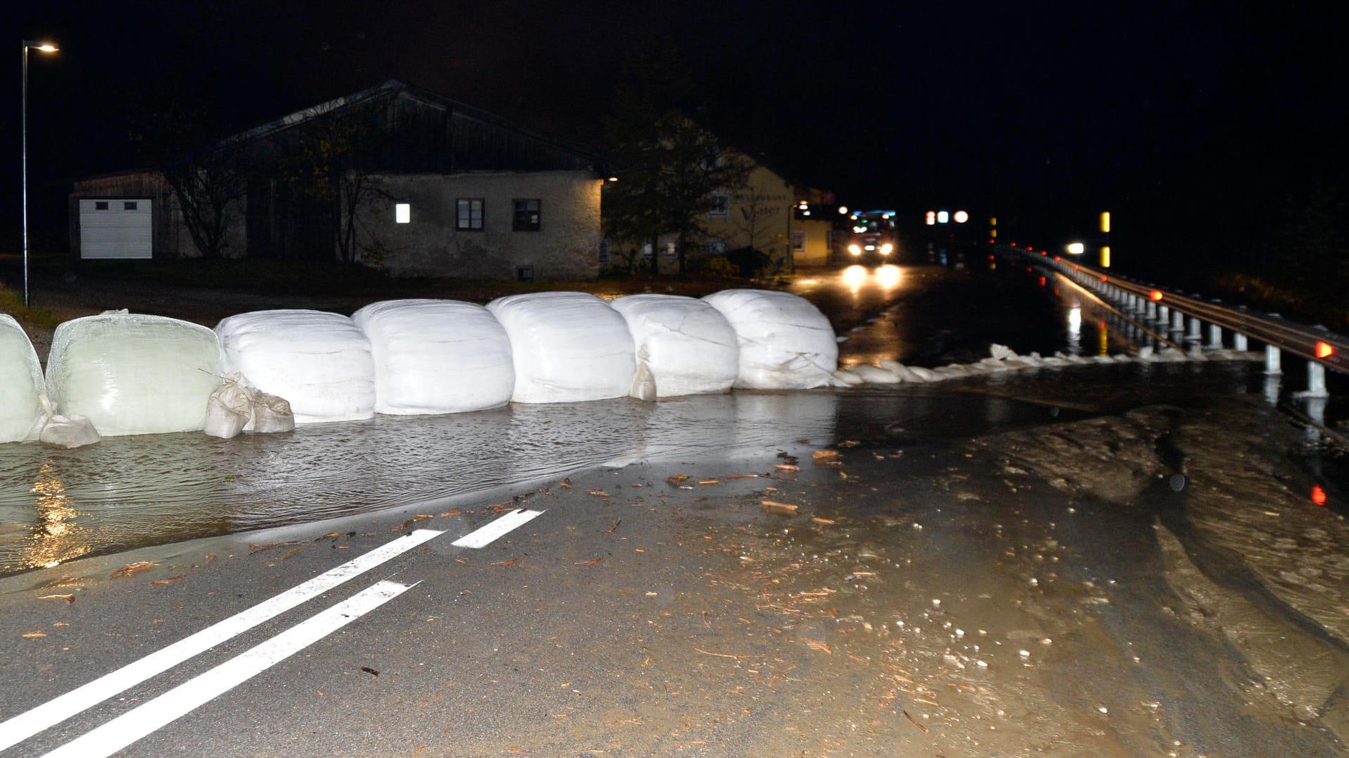 Italien, Sterzing: Eingepackte Heuballen und Sandsäcke liegen als Barriere gegen Wasser und Schlamm auf der Brenner-Bundesstraße. Nach heftigen Unwettern sind in Italien Muren abgegangen. Auch die nahe gelegene Brennerautobahn musste gesperrt werden.