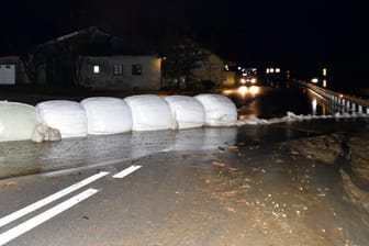 Italien, Sterzing: Eingepackte Heuballen und Sandsäcke liegen als Barriere gegen Wasser und Schlamm auf der Brenner-Bundesstraße. Nach heftigen Unwettern sind in Italien Muren abgegangen. Auch die nahe gelegene Brennerautobahn musste gesperrt werden.