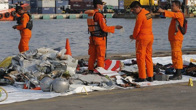 Mitarbeiter der Indonesischen Such- und Rettungsbehörde inspizieren Trümmerteile. Mitarbeiter der Indonesischen Such- und Rettungsbehörde inspizieren Trümmerteile.