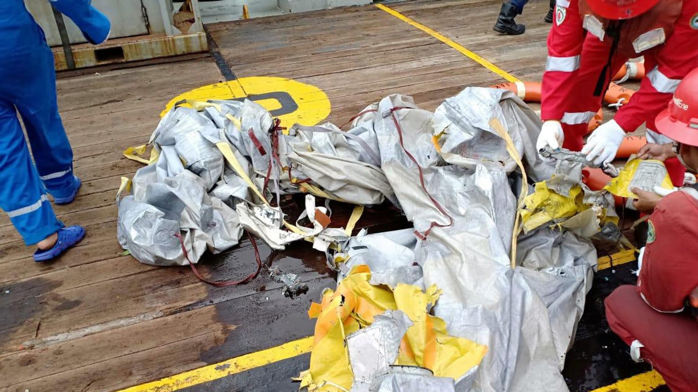 Indonesien: Die Besatzung eines Schiffes untersucht Wrackteile, die von dem abgestürzten Flugzeug stammen könnten.