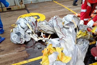 Indonesien: Die Besatzung eines Schiffes untersucht Wrackteile, die von dem abgestürzten Flugzeug stammen könnten.