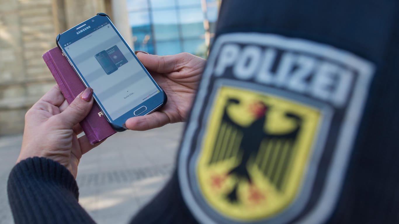 Eine Bundespolizistin scannt mit einem Mobiltelefon einen Reisepass: Die neue Methode soll effizienter und schneller als Funk sein.