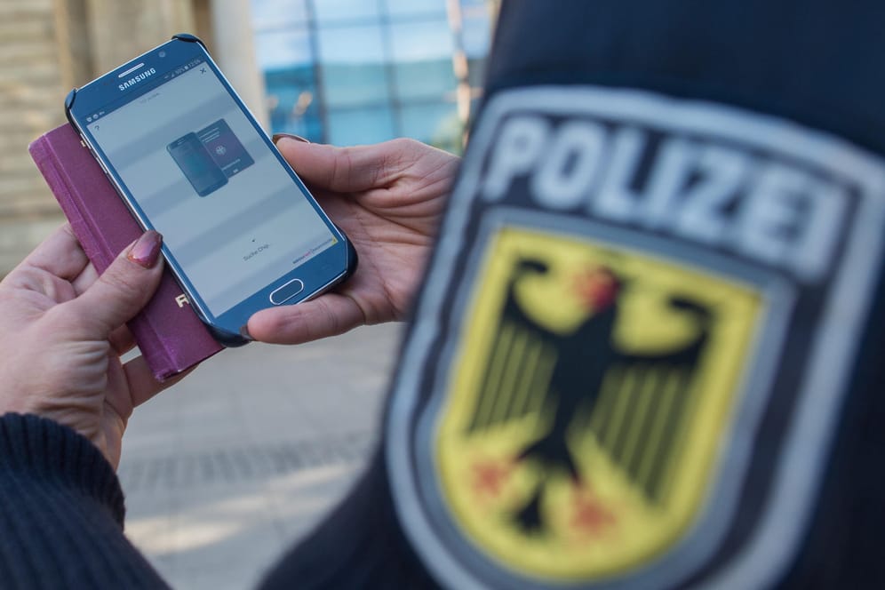 Eine Bundespolizistin scannt mit einem Mobiltelefon einen Reisepass: Die neue Methode soll effizienter und schneller als Funk sein.