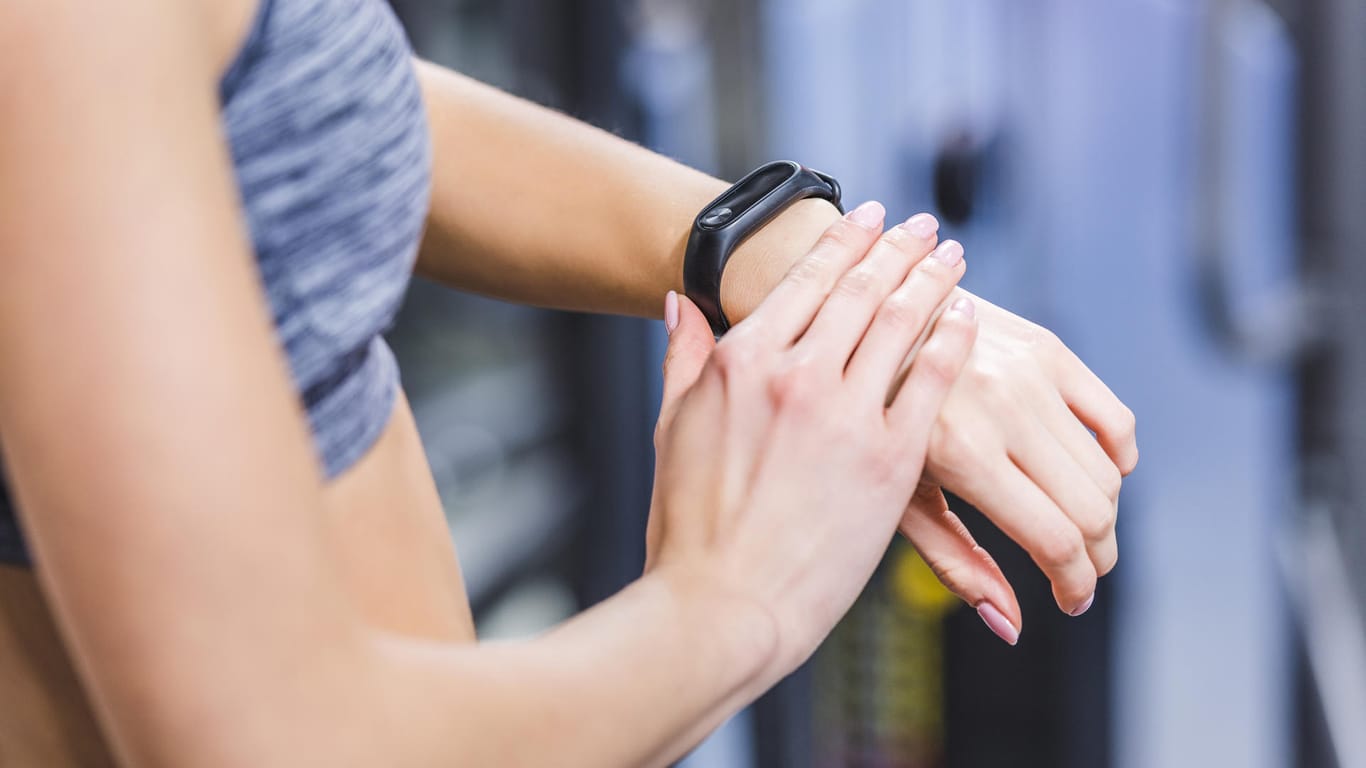 cropped shot of woman checking fitness tracker