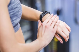 cropped shot of woman checking fitness tracker