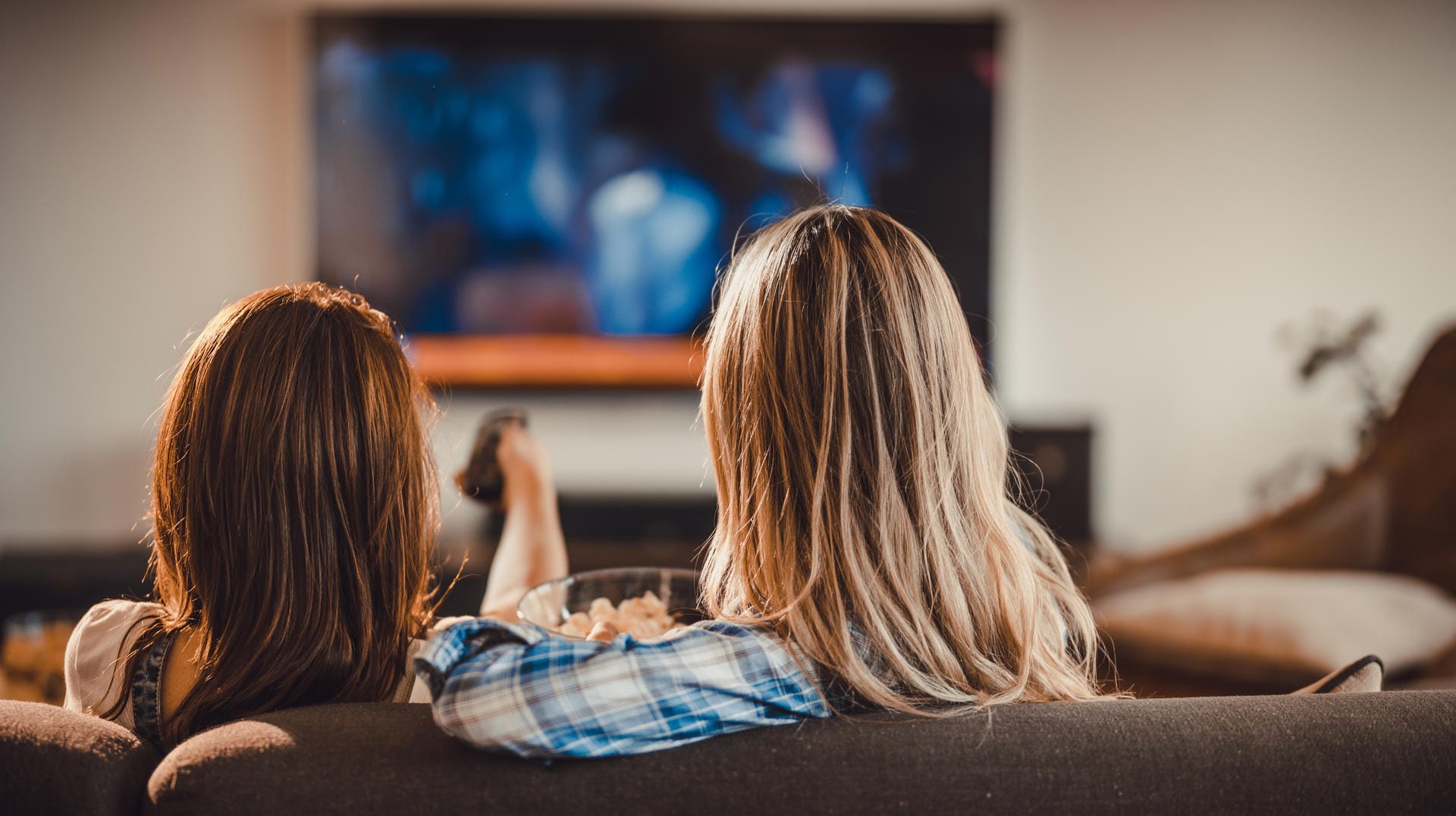 Zwei junge Frauen entspannen vor dem Fernseher: Farbprächtige OLED-Display haben eine Schwäche - sie brennen leicht ein.