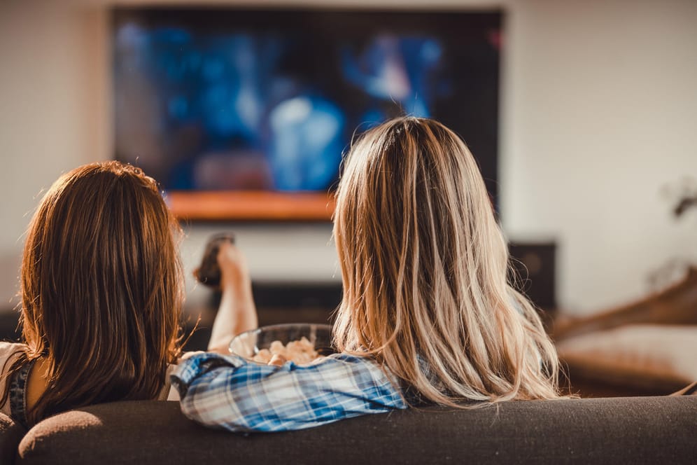 Zwei junge Frauen entspannen vor dem Fernseher: Farbprächtige OLED-Display haben eine Schwäche - sie brennen leicht ein.