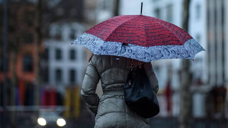 Frau mit Regenschirm in Köln: Am Dienstag muss örtlich mit Sturm und starkem Regen gerechnet werden.