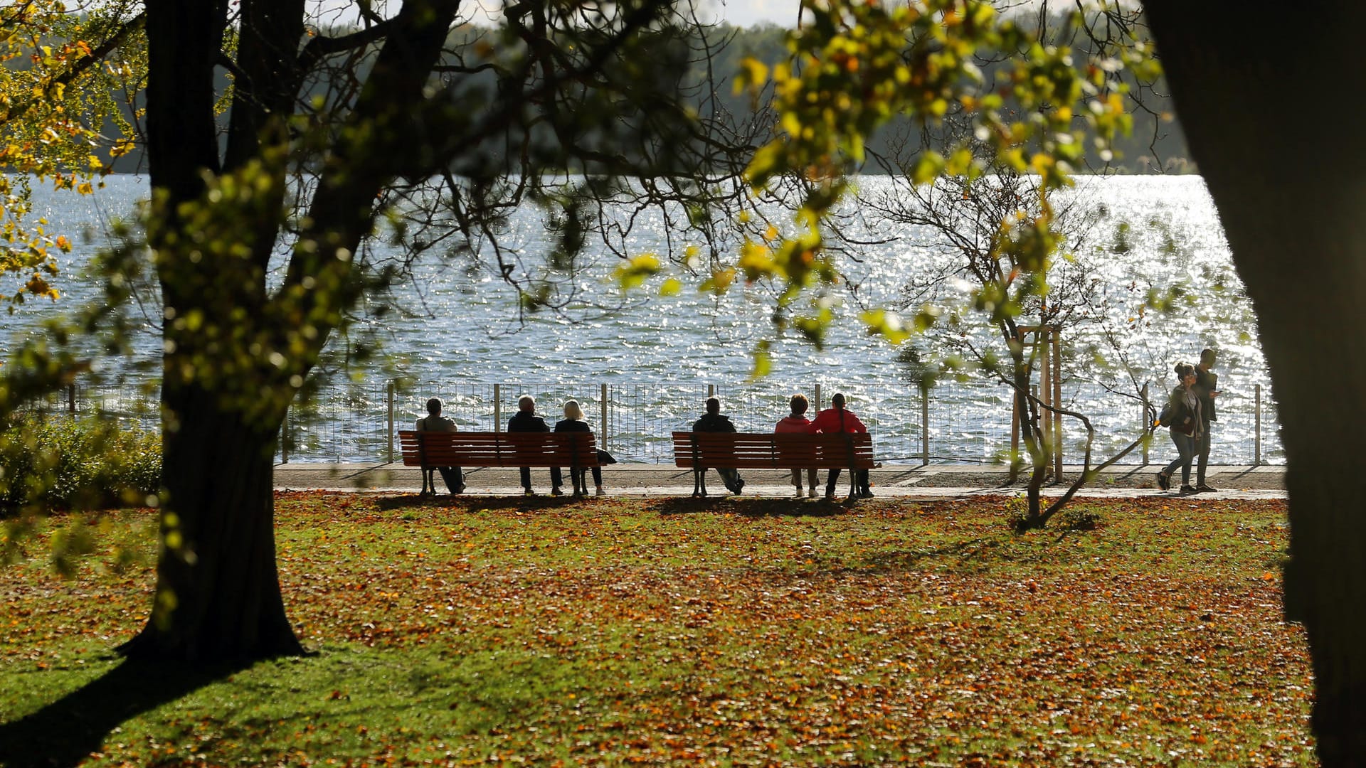 Der Müggelsee in Berlin: Bei Temperaturen um 16 Grad Celsius sitzen Menschen in der Oktobersonne.