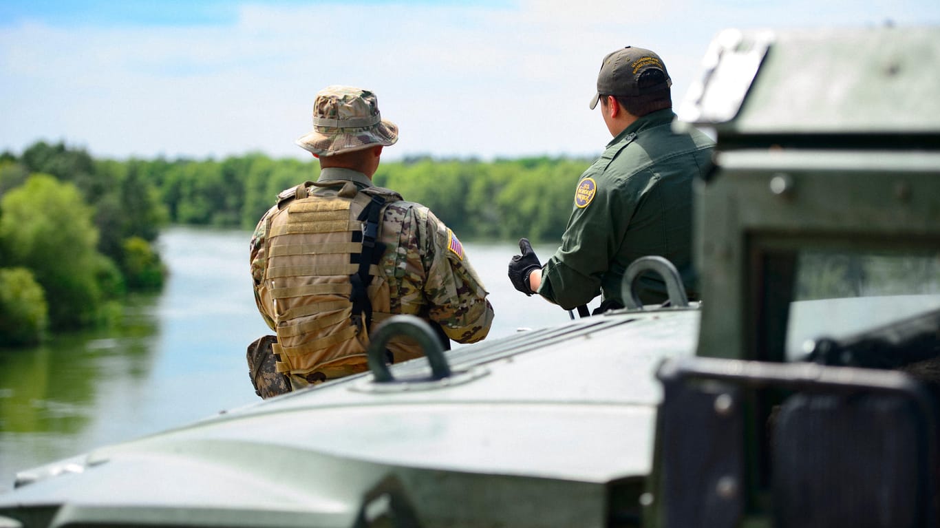 Ein Soldat und einen US-Grenzschutzbeamten, die die Umgebung entlang des Rio Grande in Starr County beobachten: Das US-Militär soll die Grenzpolizei bei logistischen Maßnahmen unterstützen. Bewaffnet sind sie trotzdem.