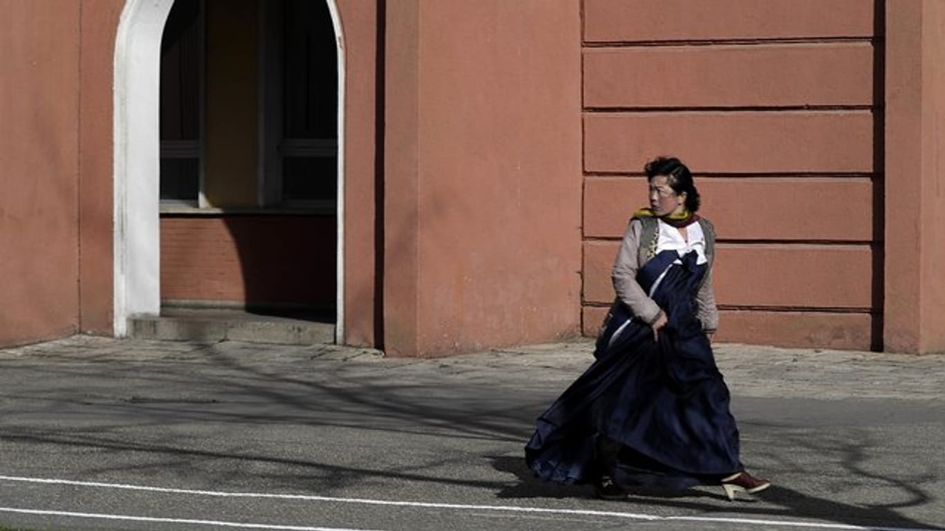 Eine Frau in einem traditionellen Kleid in einer Straße von Pjöngjang.