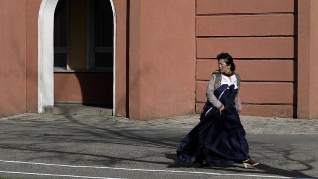 Eine Frau in einem traditionellen Kleid in einer Straße von Pjöngjang.