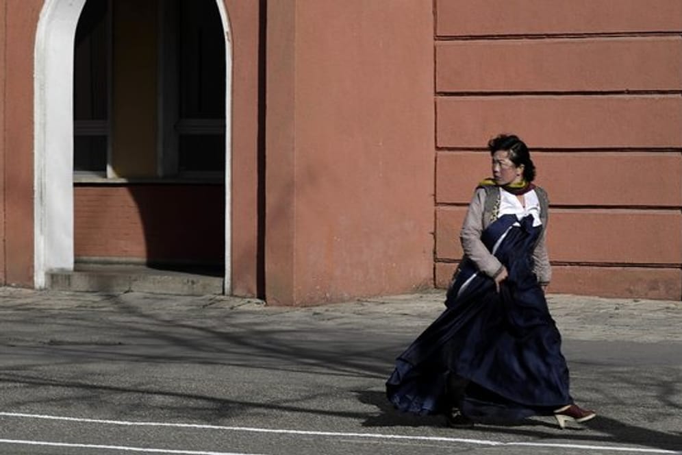 Eine Frau in einem traditionellen Kleid in einer Straße von Pjöngjang.